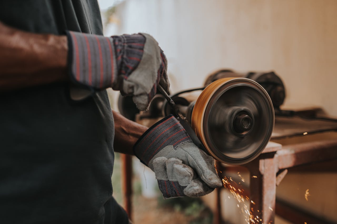 A craftsman using a grinder with sparks flying indoors, showcasing skill and precision.